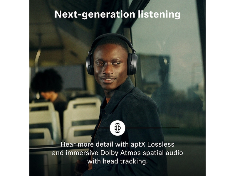Mand med sorte Sennheiser MOMENTUM 5 i en bus med sæderækker og store vinduer bag sig
