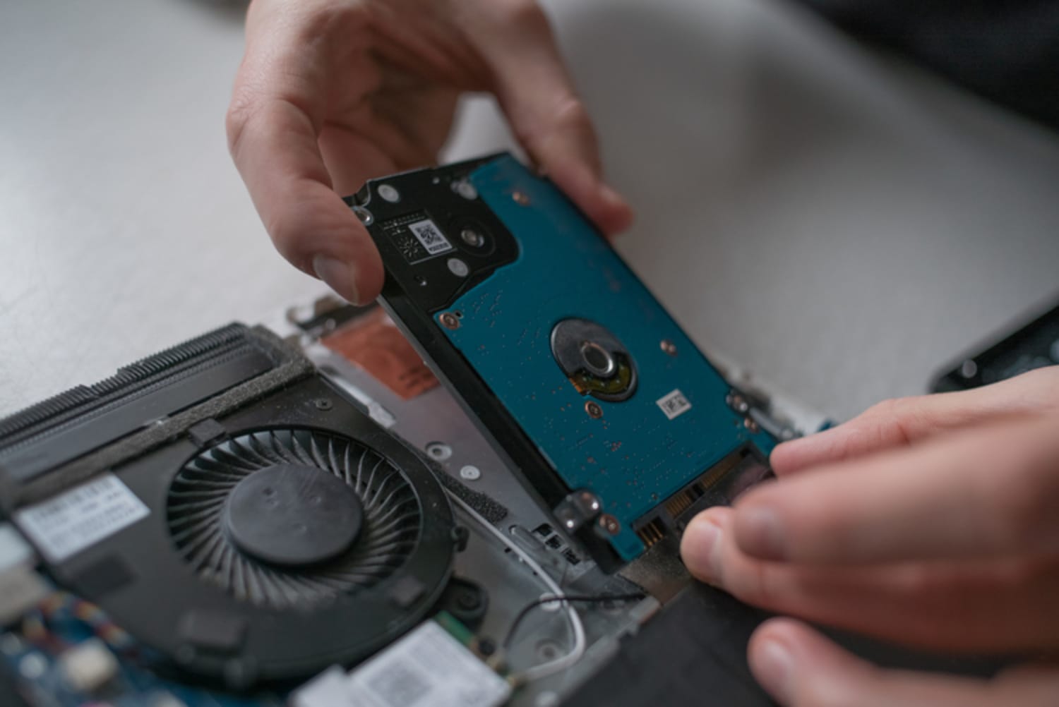 Her fjernes en mekanisk harddisk fra maskinen, og den erstattes af SSD.