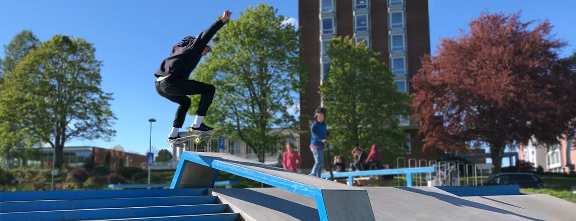Ung mand kører på skateboard ned ad en trappe i en skatepark